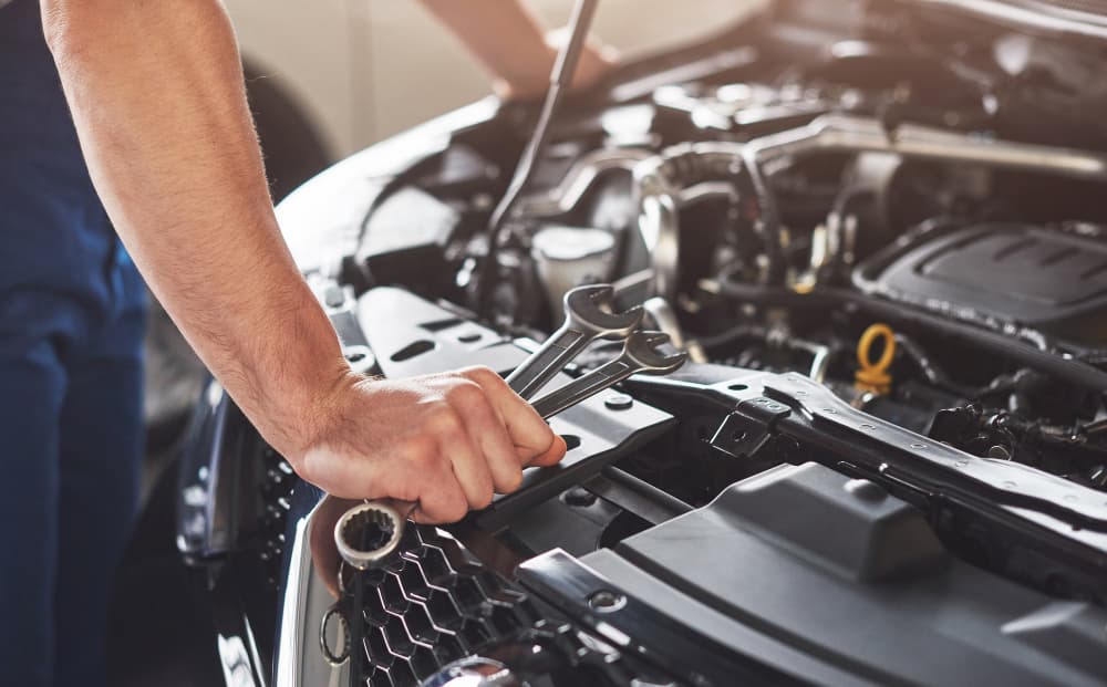 Mechanic tools positioned over an open car engine bay