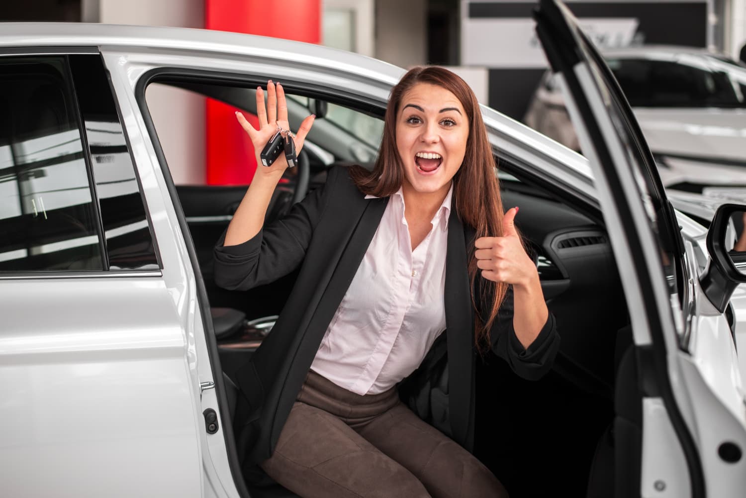 Happy customer holding car keys after a successful purchase